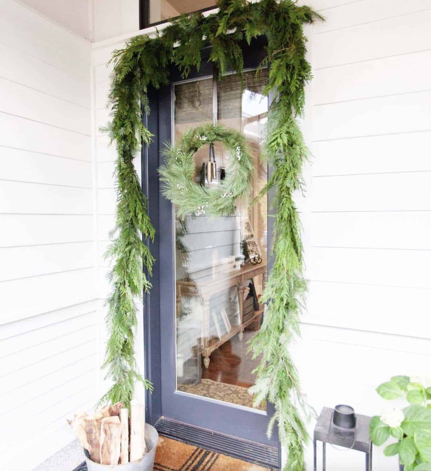 front door decorated with garland and a wreath