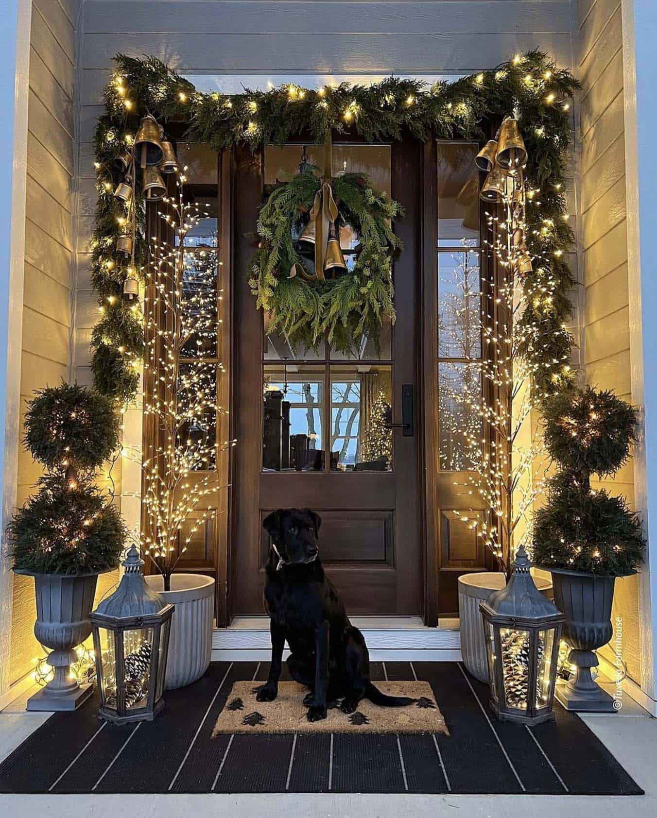 Christmas decorated front door with lighted faux greenery