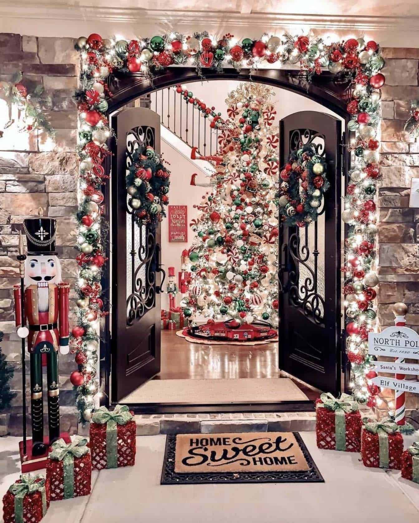 merry and bright entryway with a lifesize nutcracker, French doors and a huge Christmas tree in the entryway
