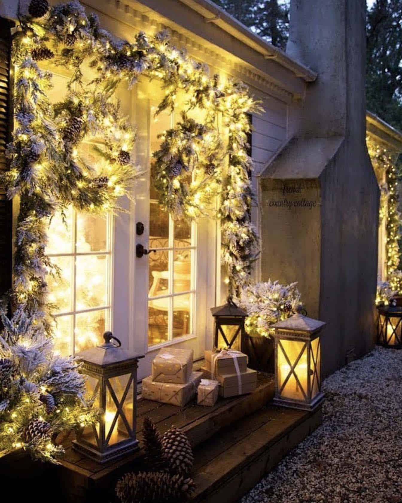front porch decorated with snowy garland and lanterns