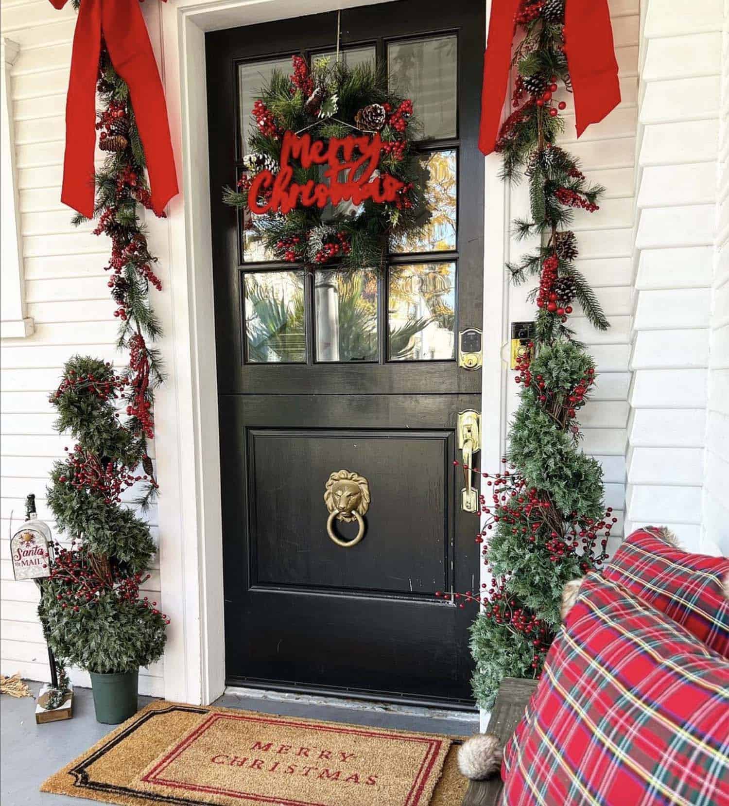 festive and cozy Christmas decorated front porch with red and green 
