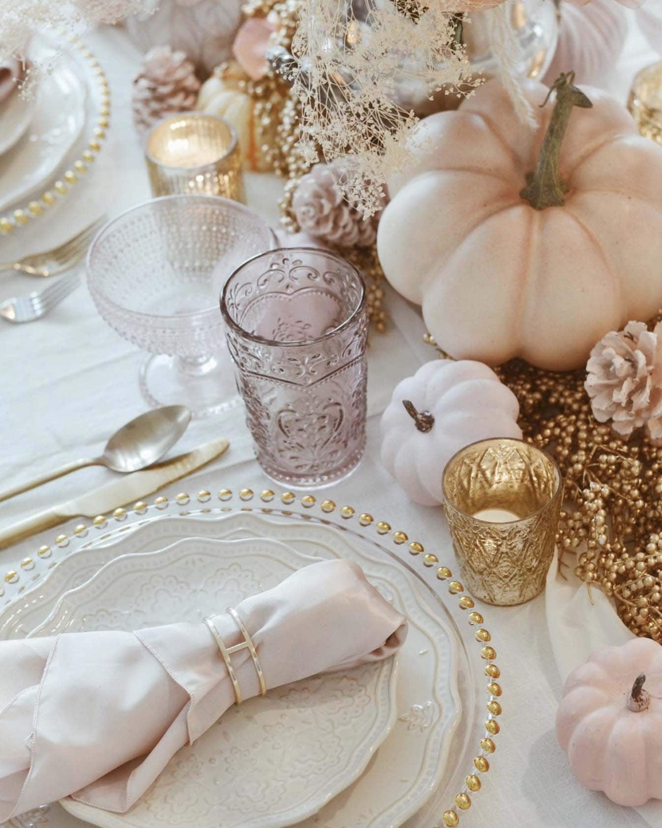 thanksgiving dining table place setting with a pastel color palette of florals and pumpkins