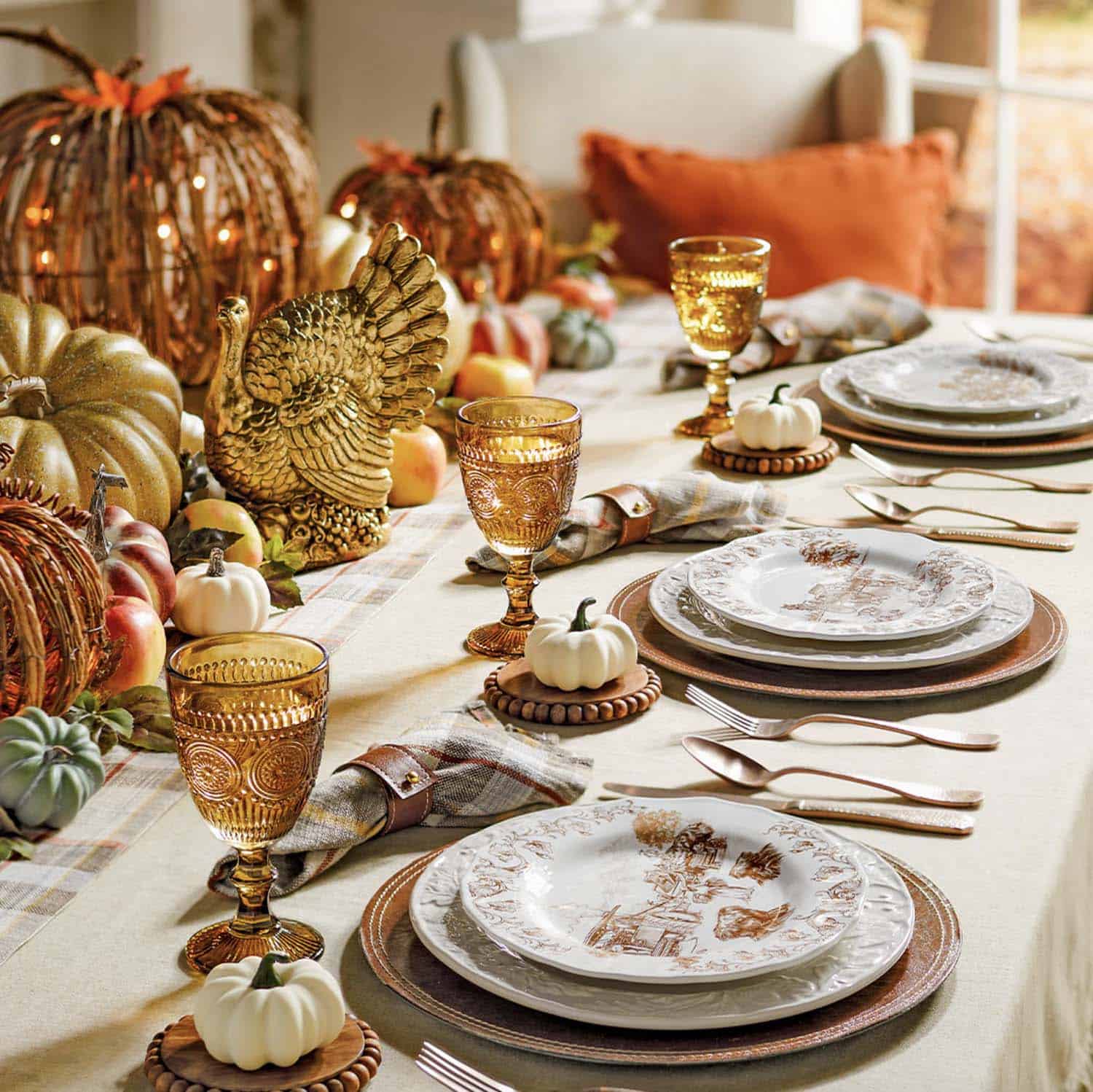 Thanksgiving table setting with gold accents and pumpkins