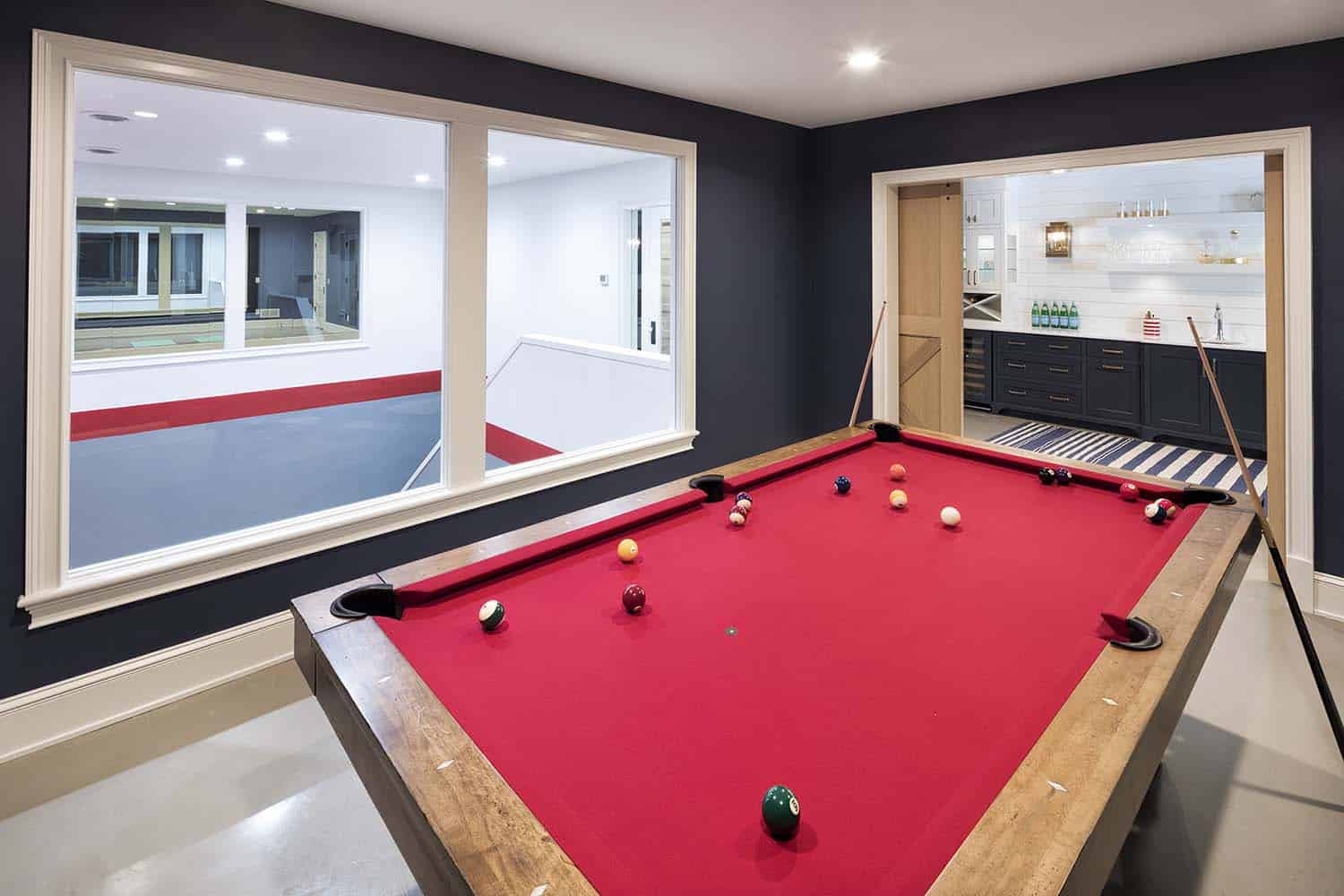 modern pool table with a view into the sport court