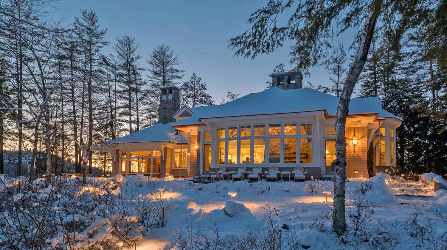 contemporary lake house exterior at dusk with snow