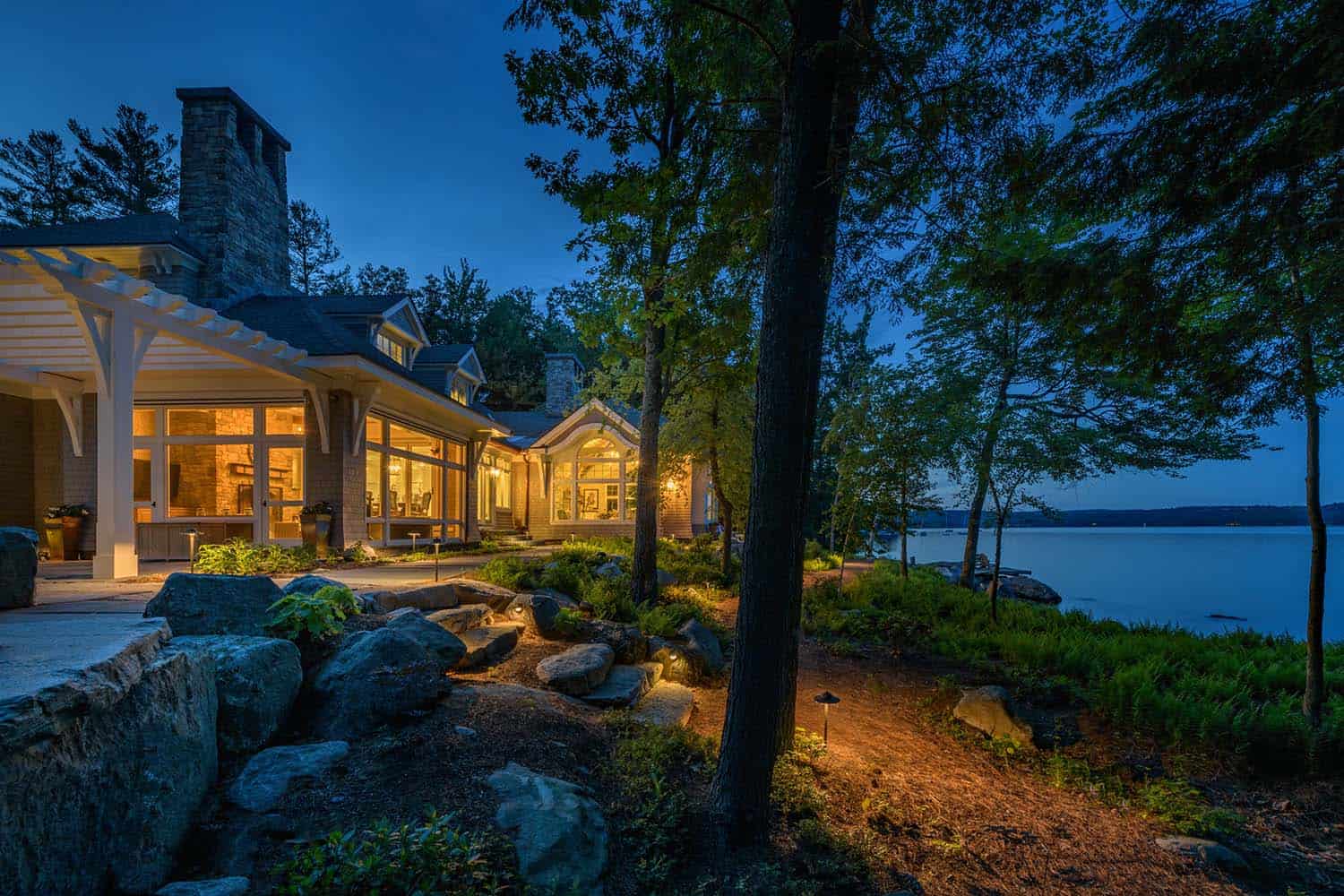 contemporary lake house exterior at dusk overlooking the water