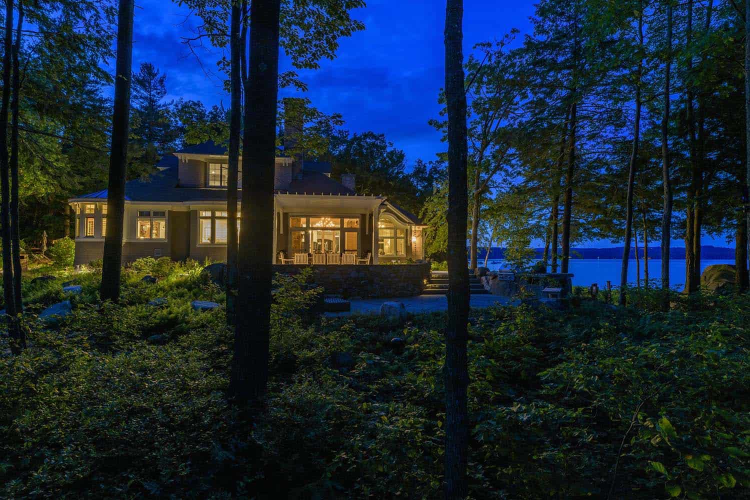 contemporary lake house exterior at dusk overlooking the water