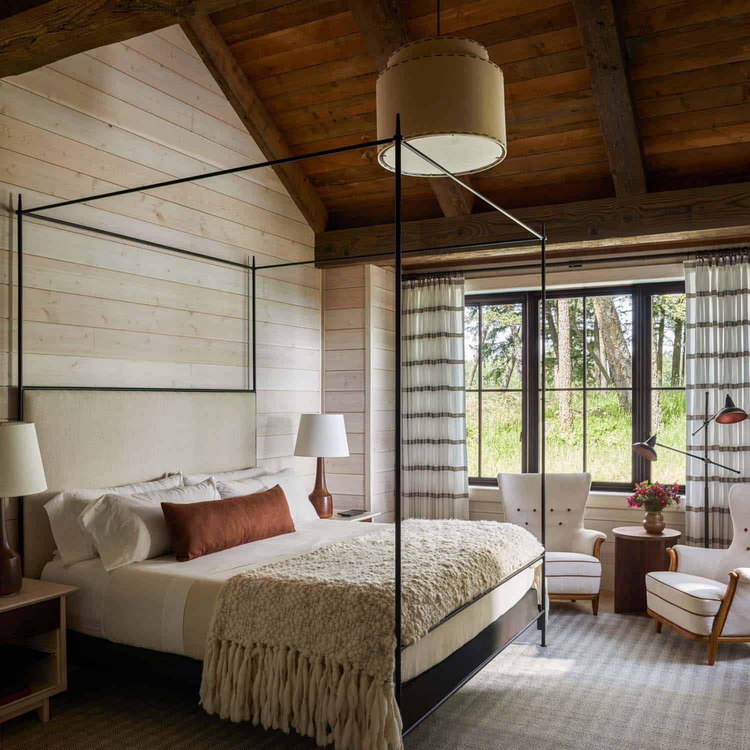 modern rustic bedroom with a canopy bed and vaulted ceiling
