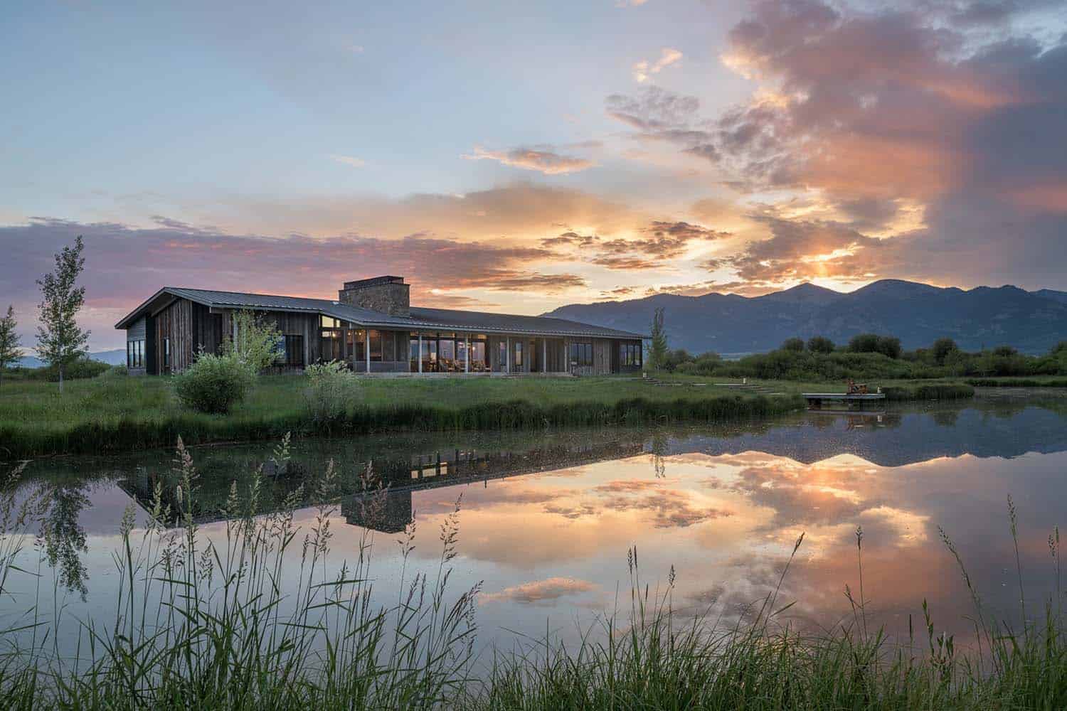 modern rustic retreat exterior with a view of the Wyoming river at sunset