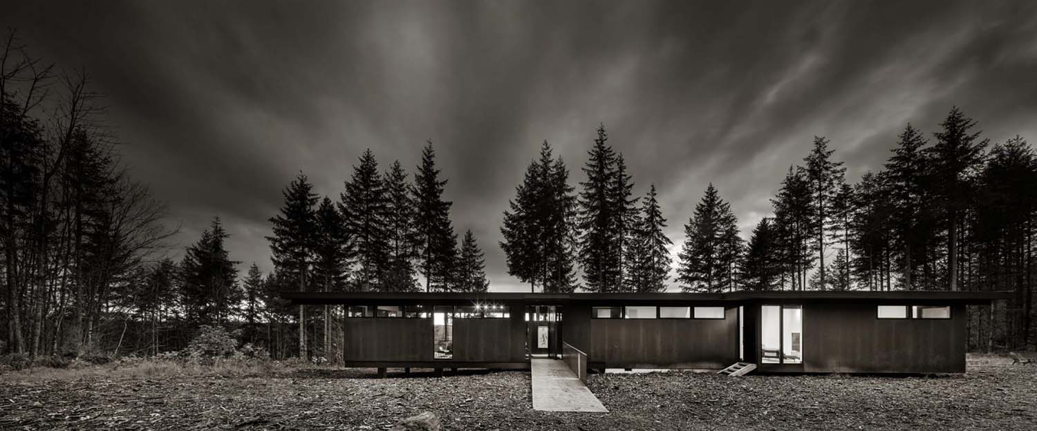 modern steel forest house exterior black and white image