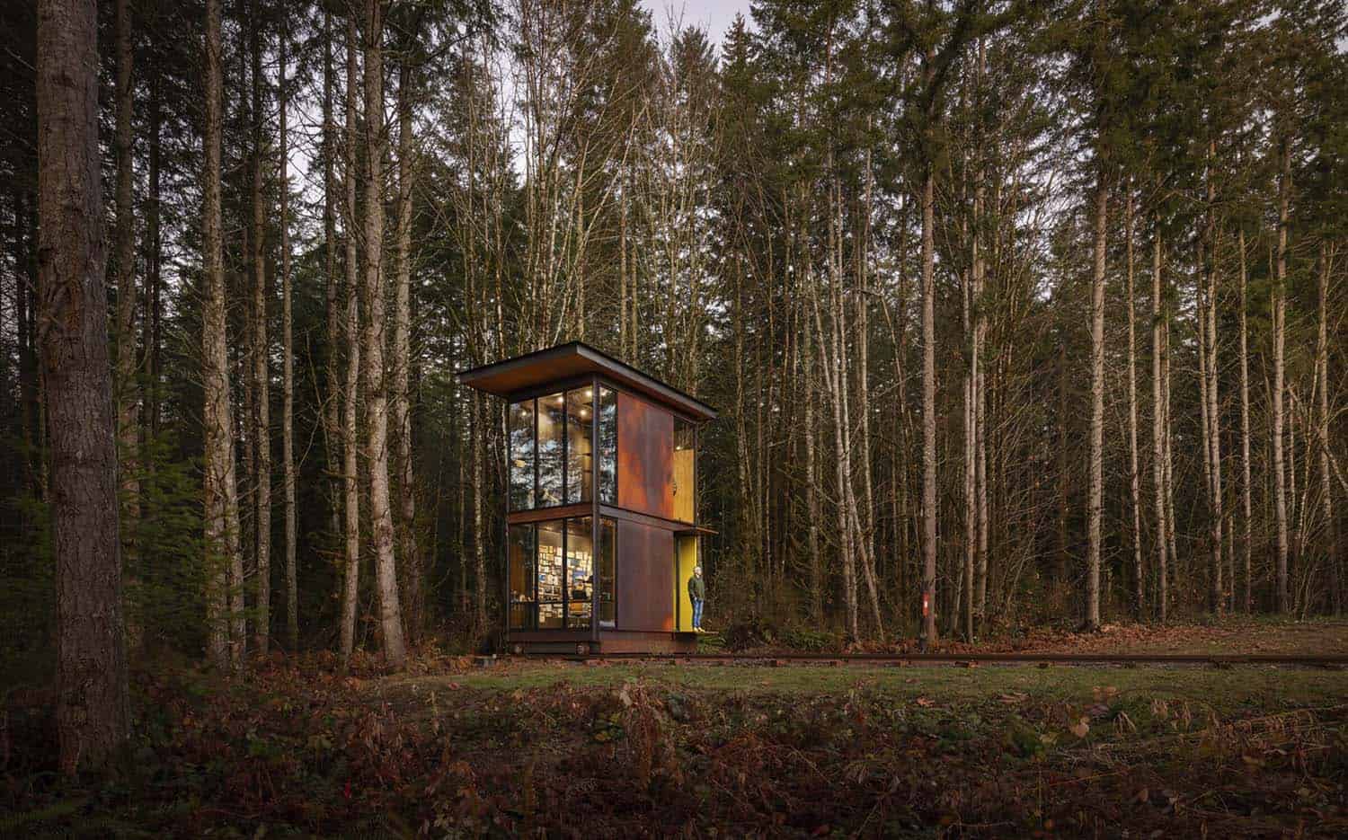 modern steel tower home office exterior in the forest on railroad tracks