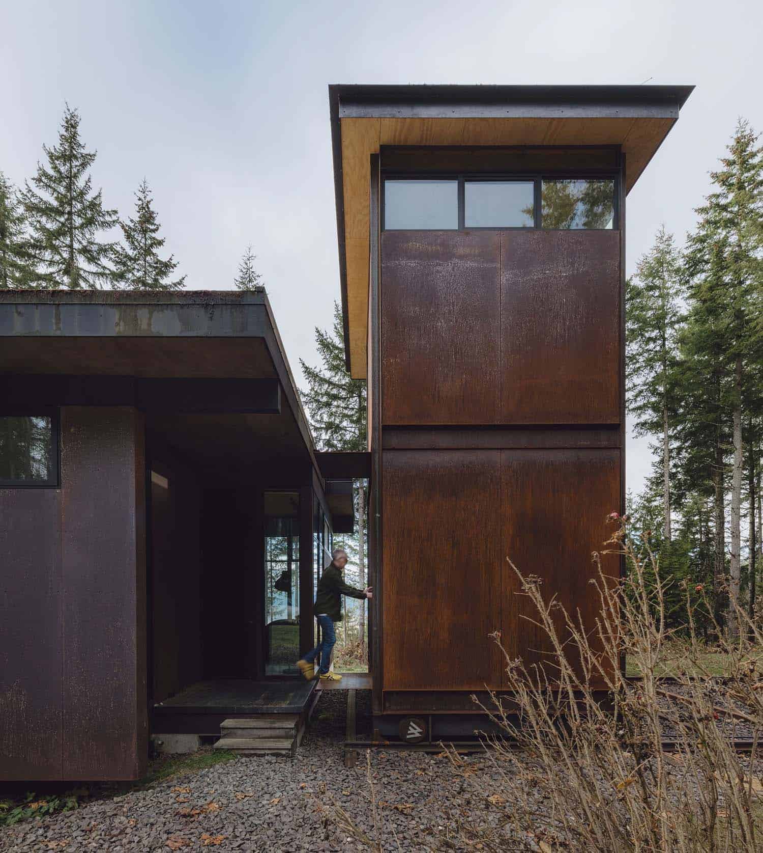 modern steel tower home office exterior in the forest on railroad tracks