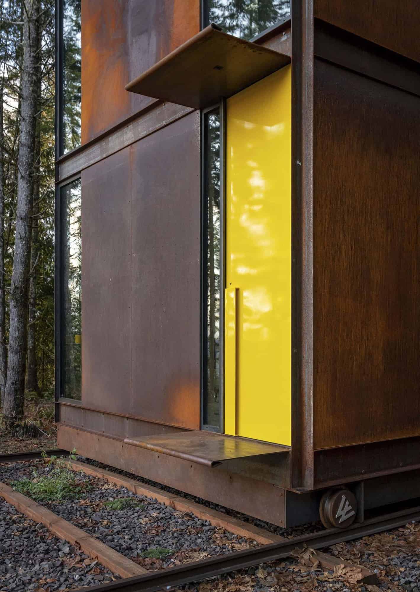 modern steel tower home office exterior with a yellow door