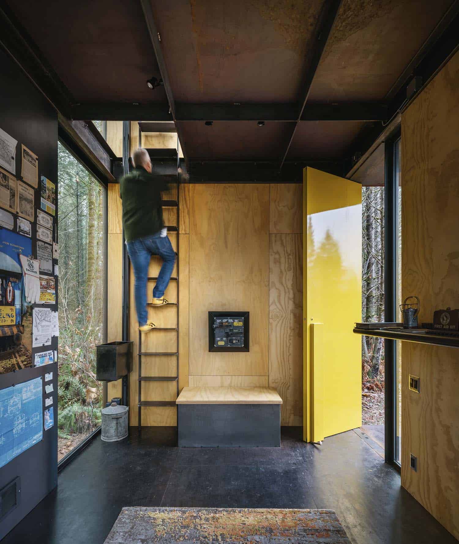 modern home office with a yellow front door and ladder leading to a loft
