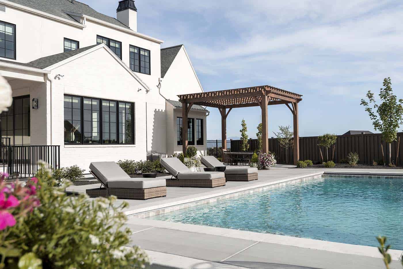 modern Tudor style home exterior with a pool