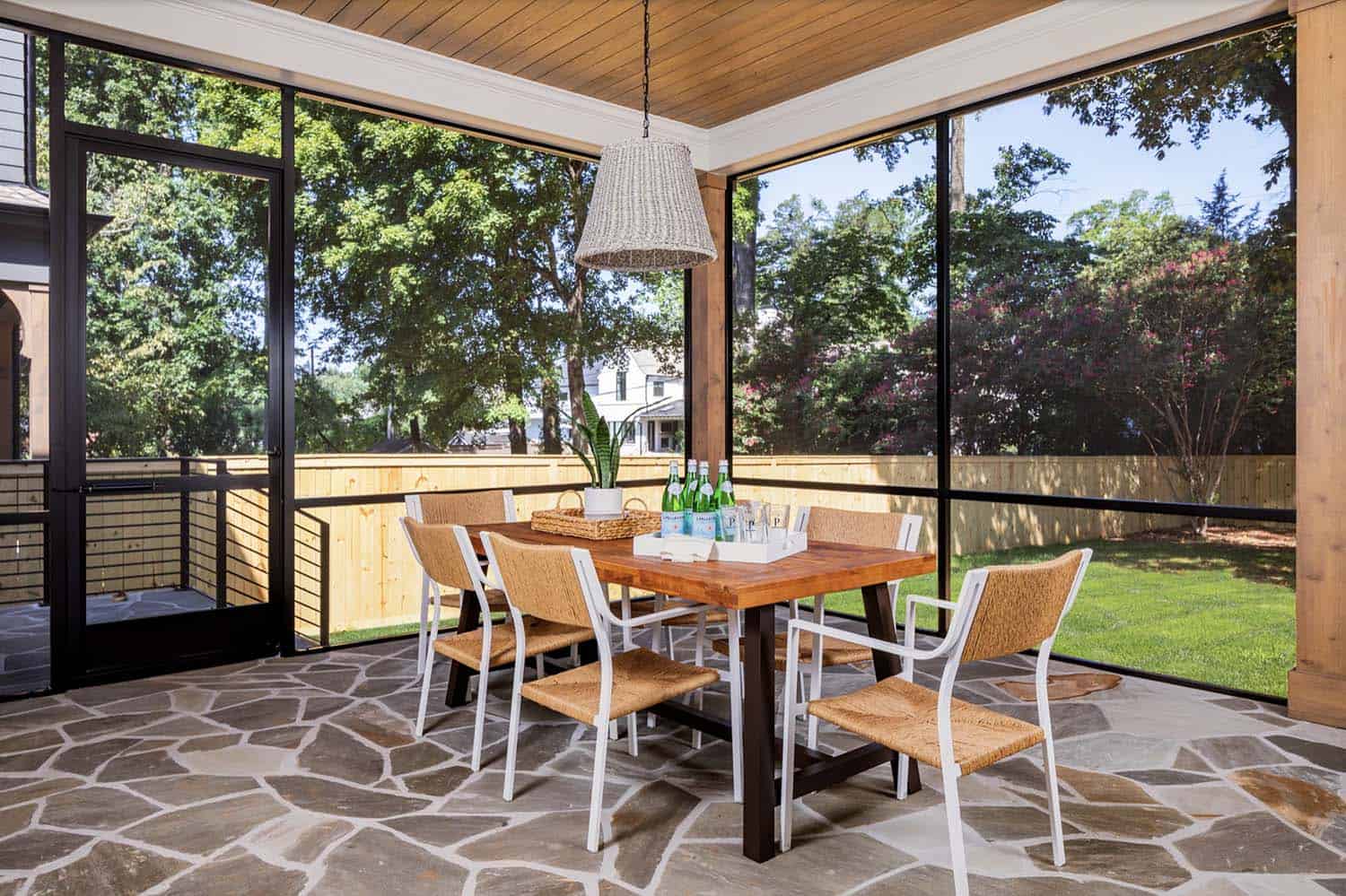 transitional style screened porch with outdoor dining table
