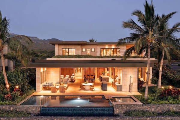 contemporary beach house with a backyard view of the pool at dusk