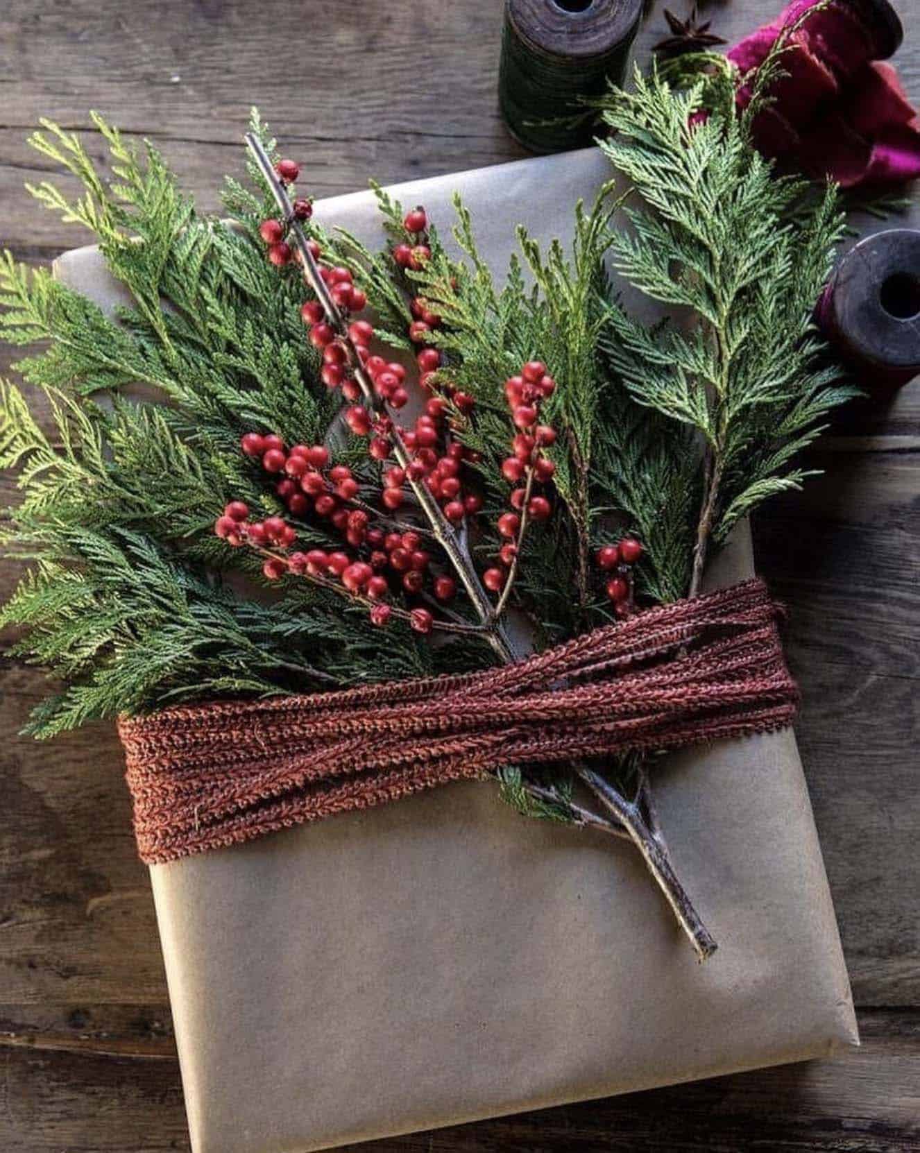 christmas present with Kraft paper, pine branches and berries