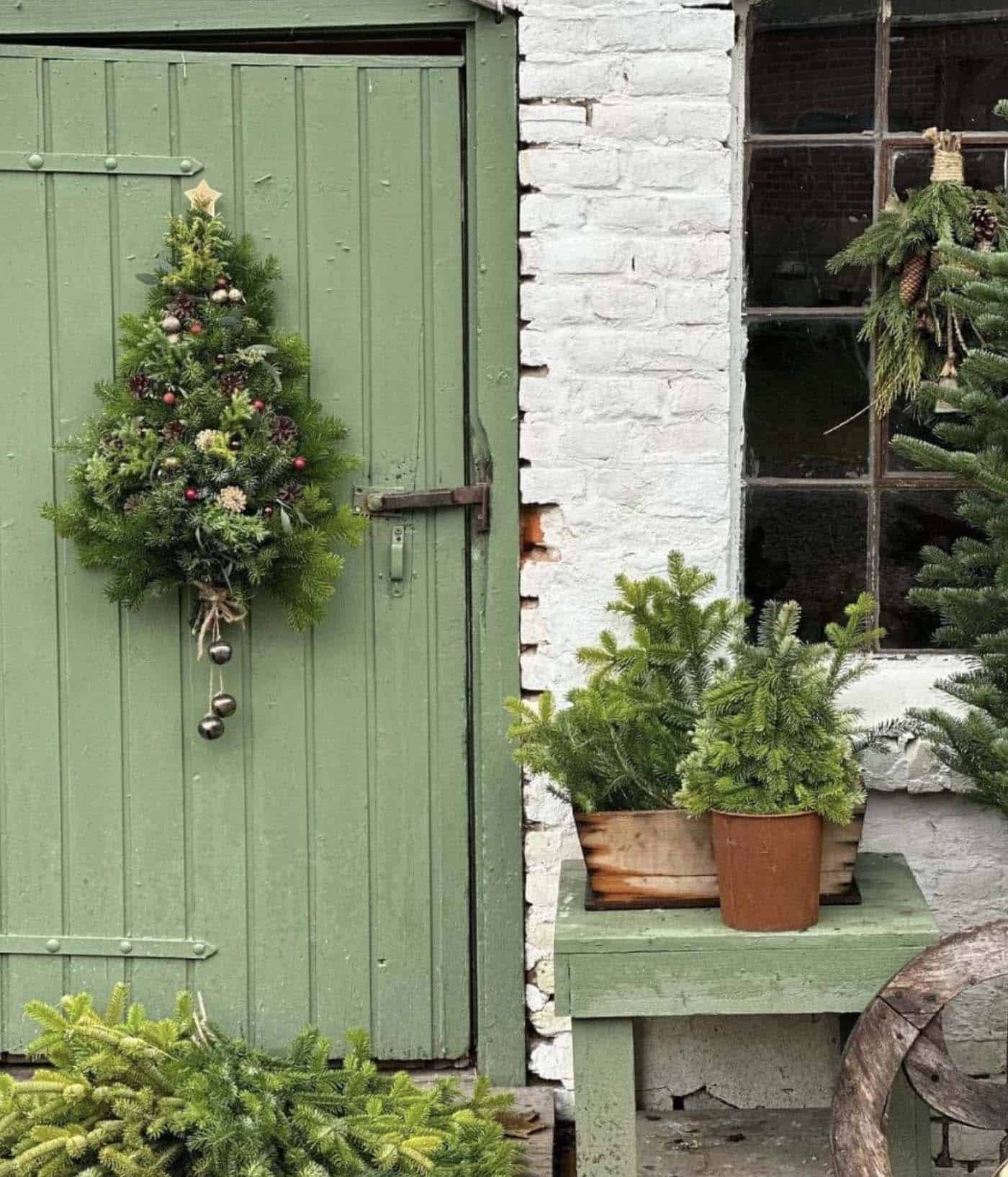 green painted door with a tree-shaped christmas wreath