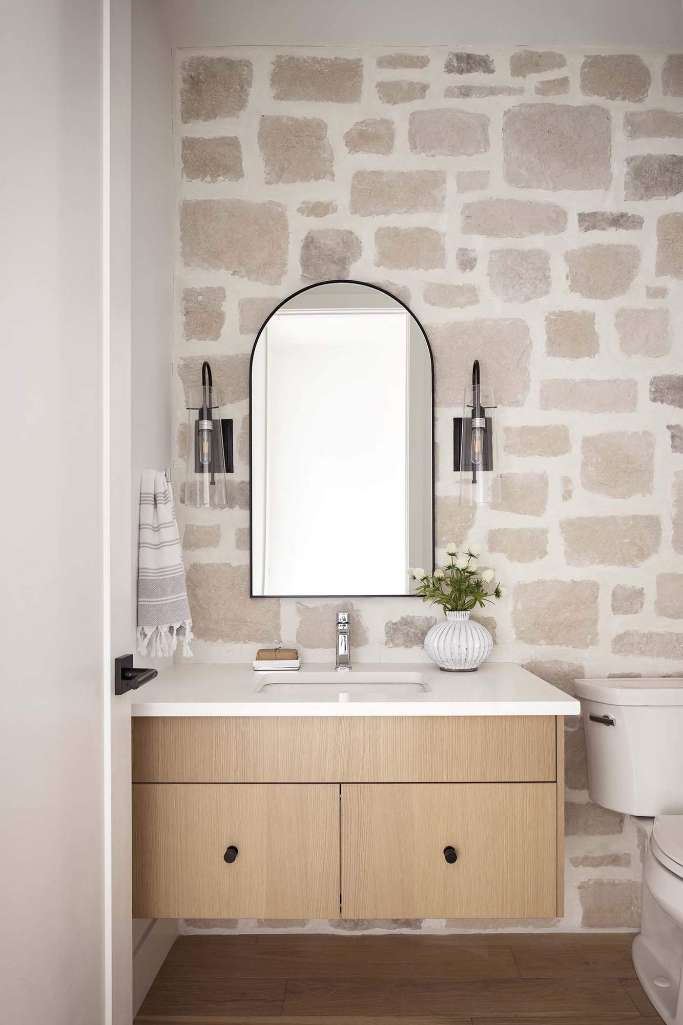 modern farmhouse powder room with a stone accent wall