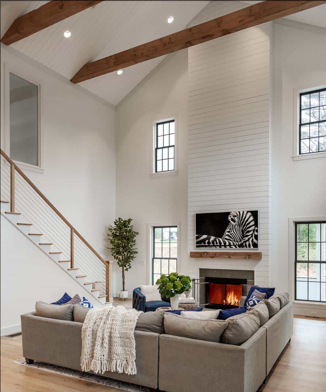 modern farmhouse living room with a tall ceiling and a fireplace