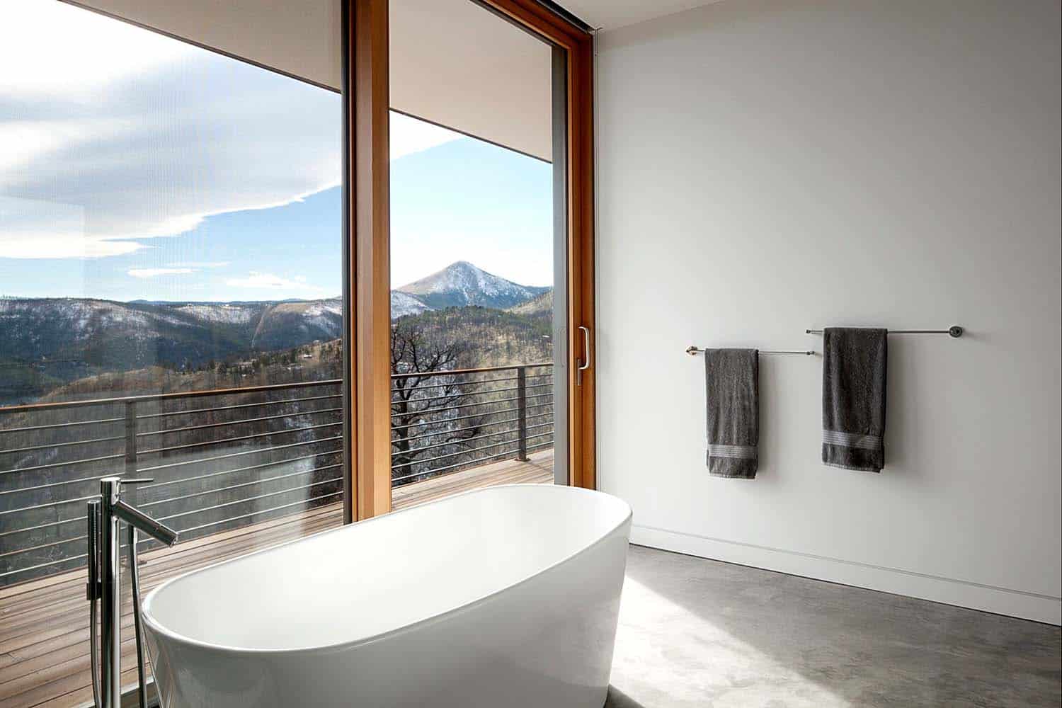 modern bathroom with a freestanding tub and a large window view