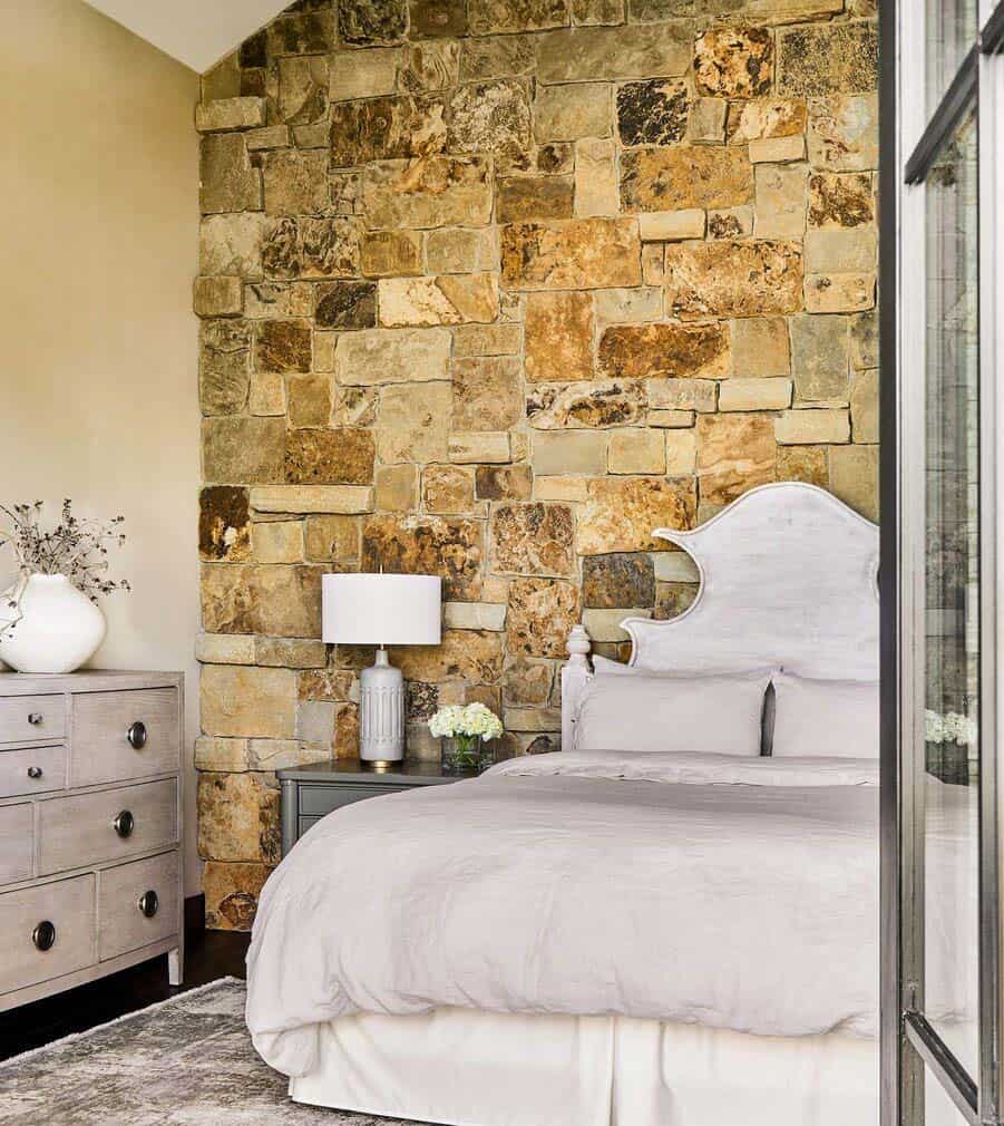 rustic bedroom with a stone accent wall