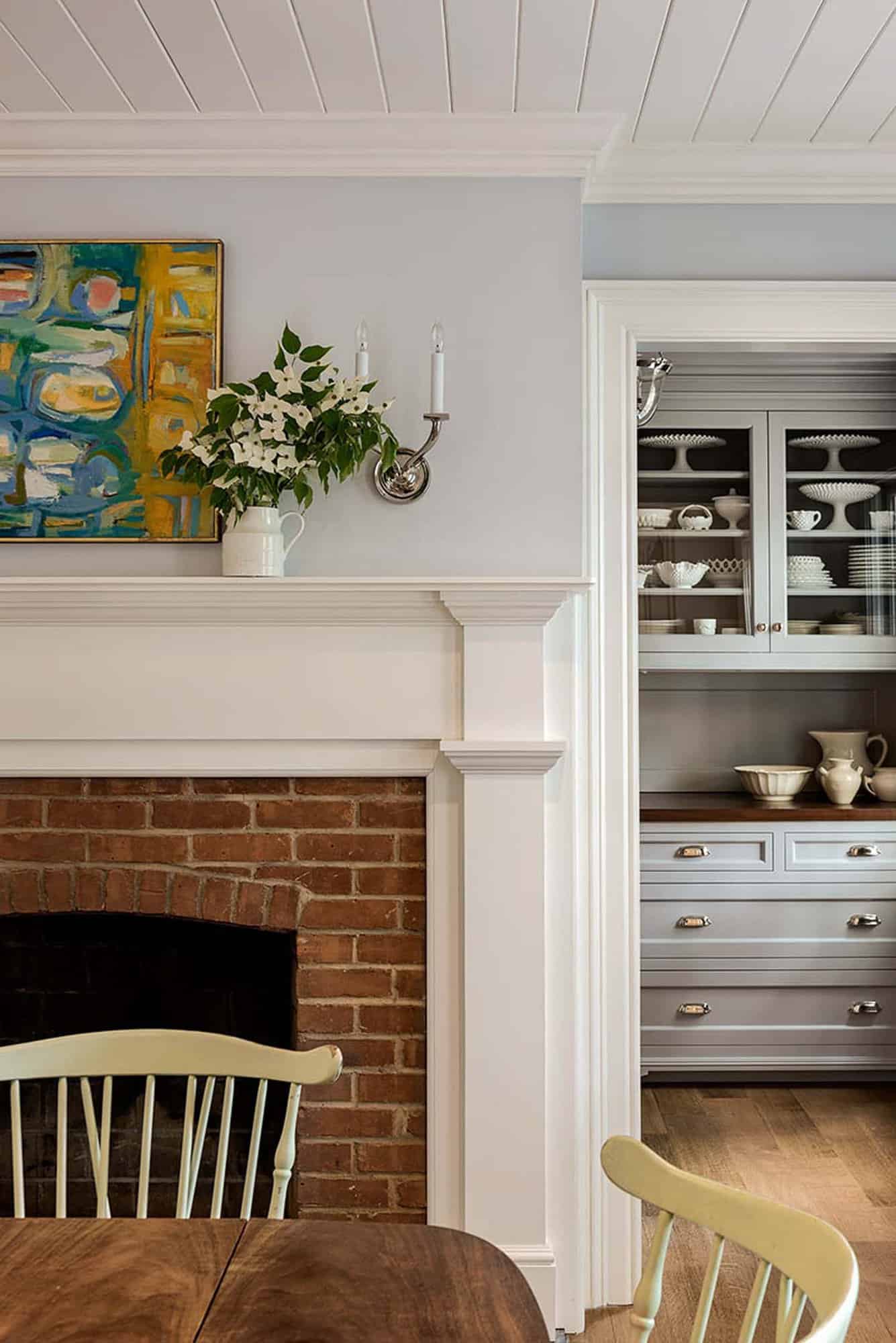 transitional style dining room fireplace detail with a brick surround