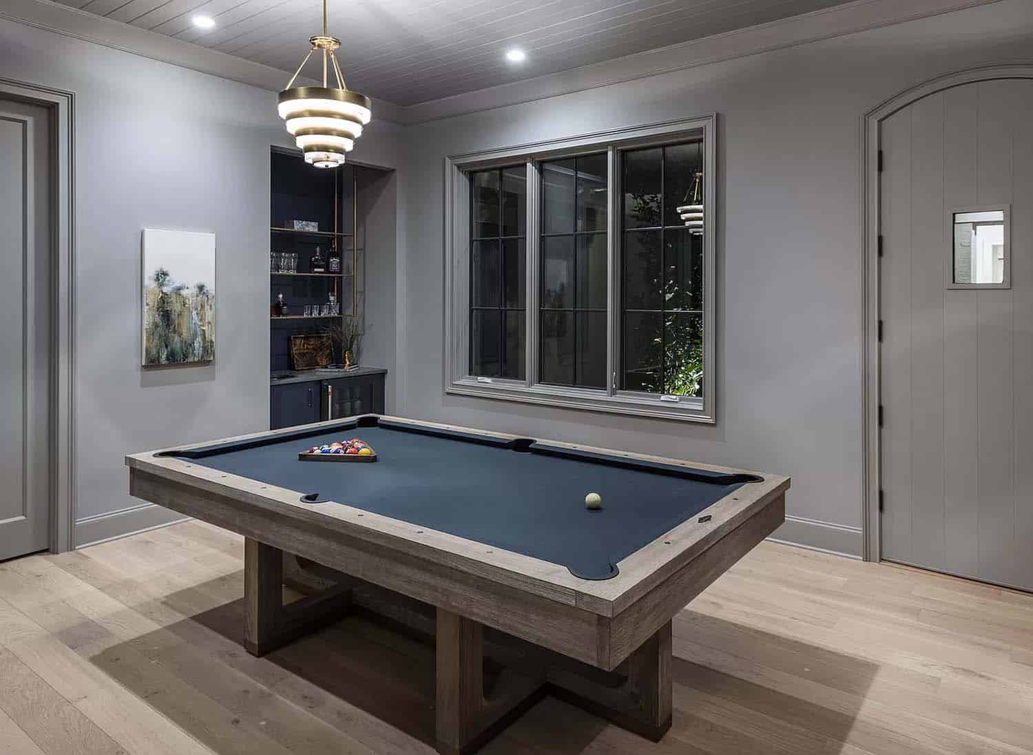contemporary entertainment room with a pool table at dusk