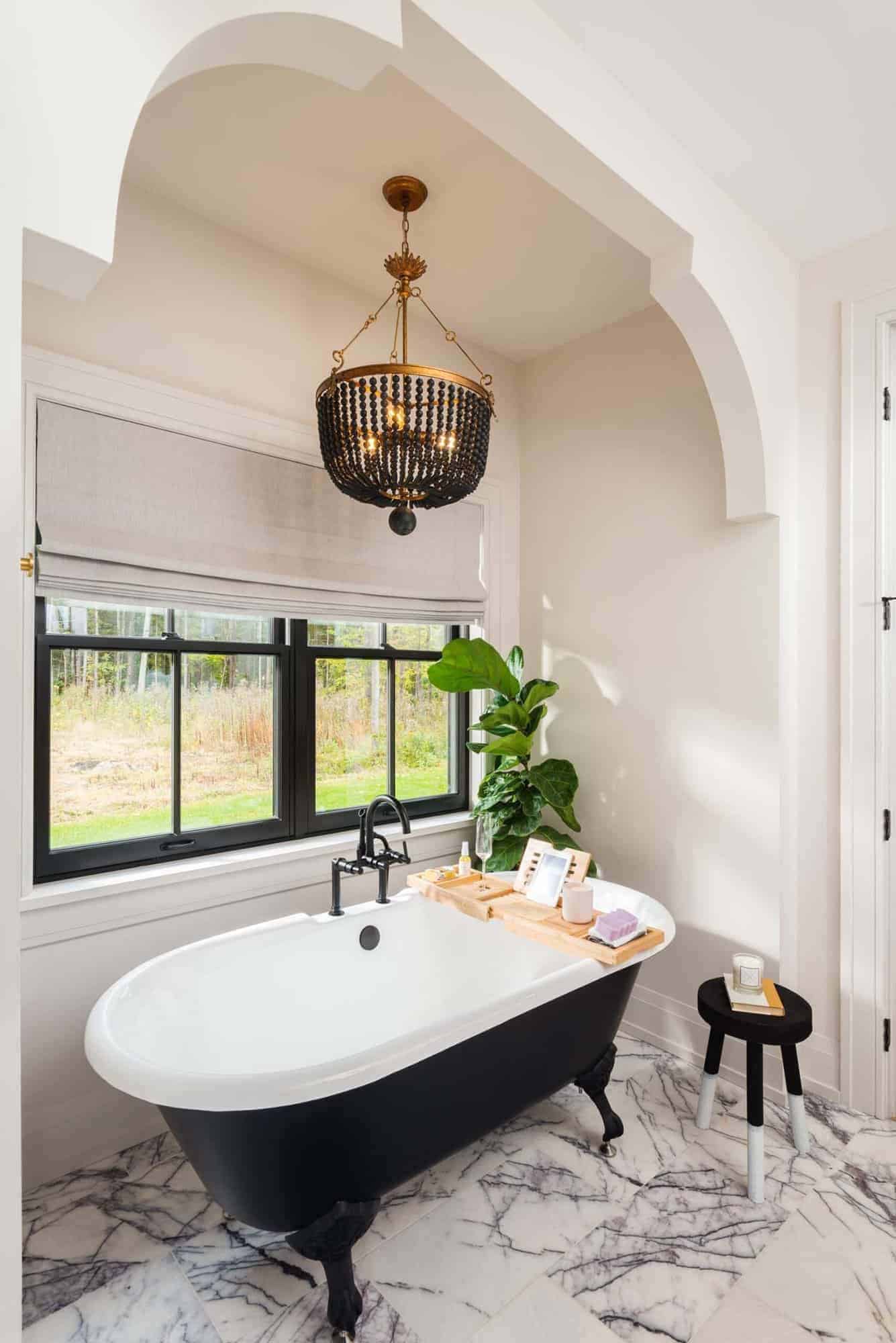 contemporary bathroom with a freestanding tub and large chandelier