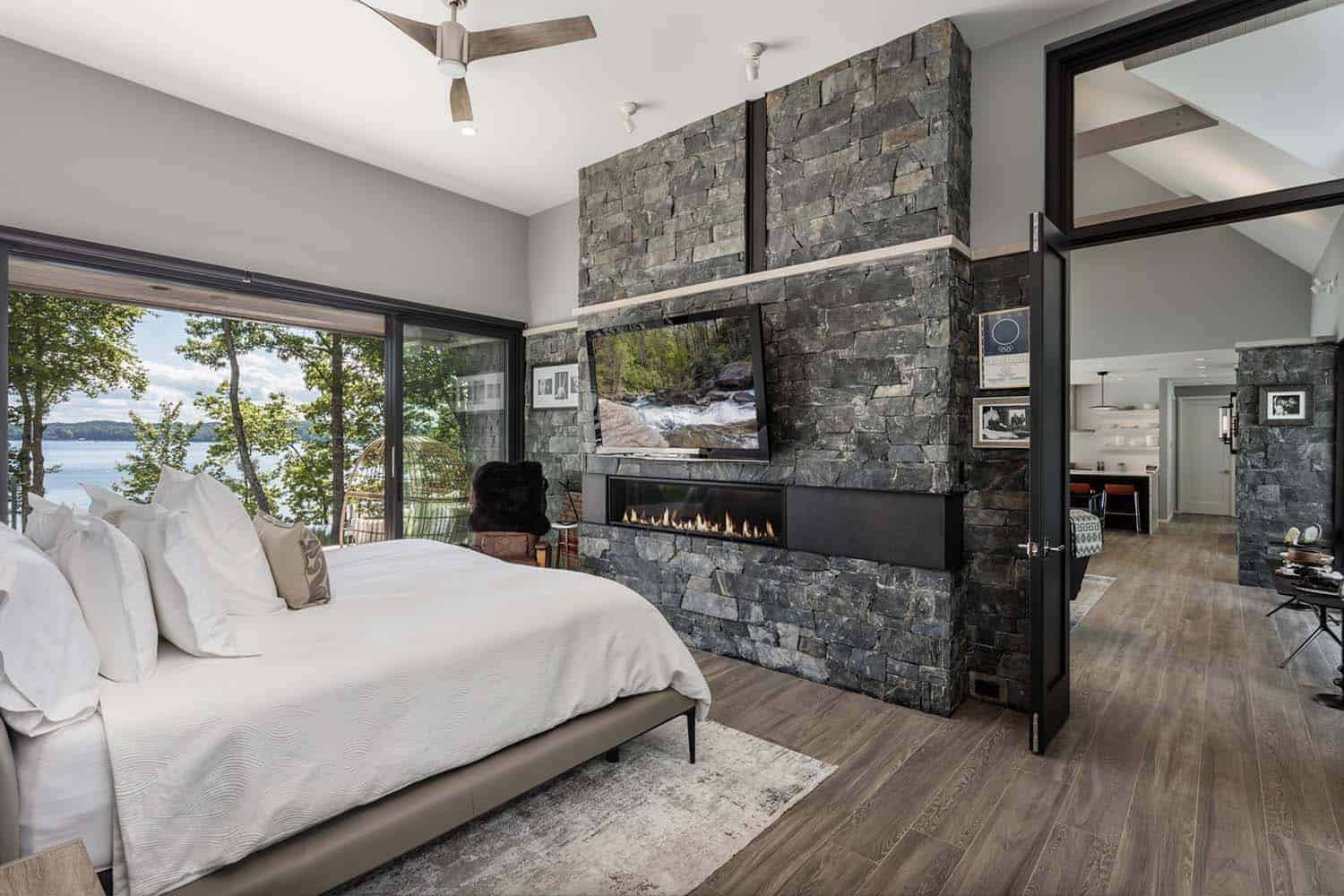 contemporary mountain style bedroom with a stone clad fireplace