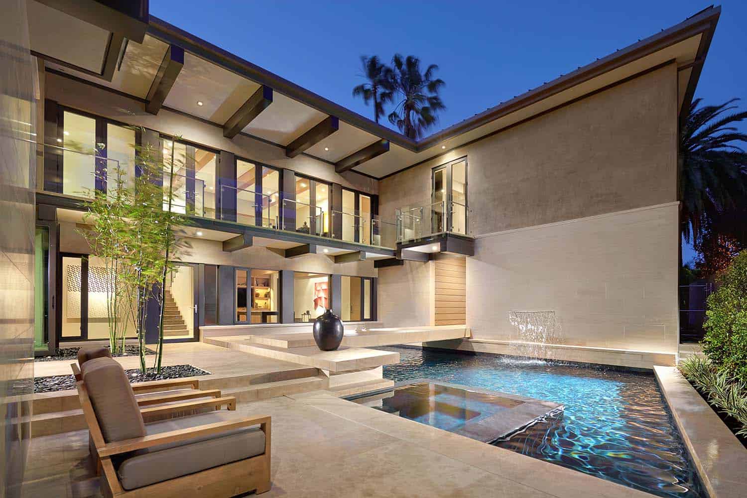 contemporary home exterior with a pool at dusk
