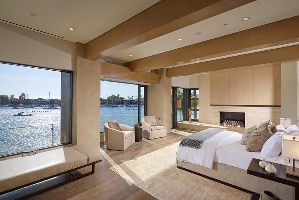contemporary bedroom with large windows and a water view