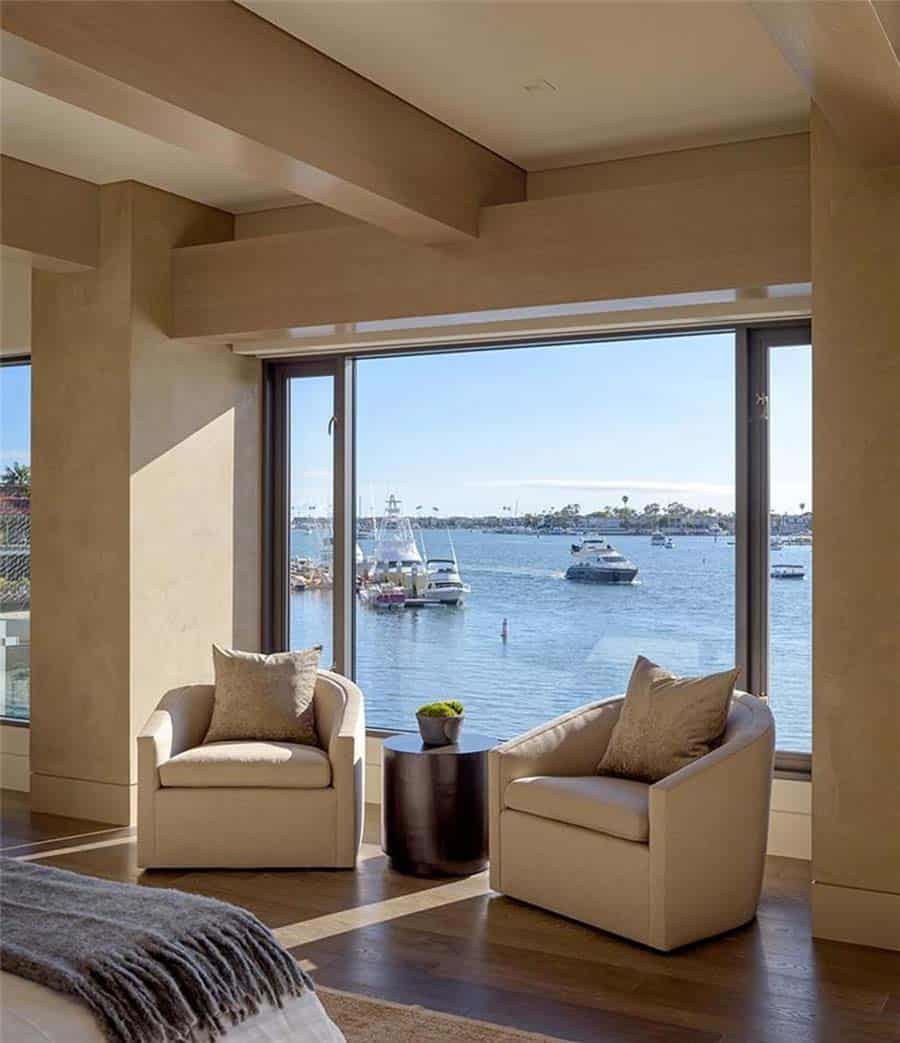 contemporary bedroom seating area with a large window and a water view