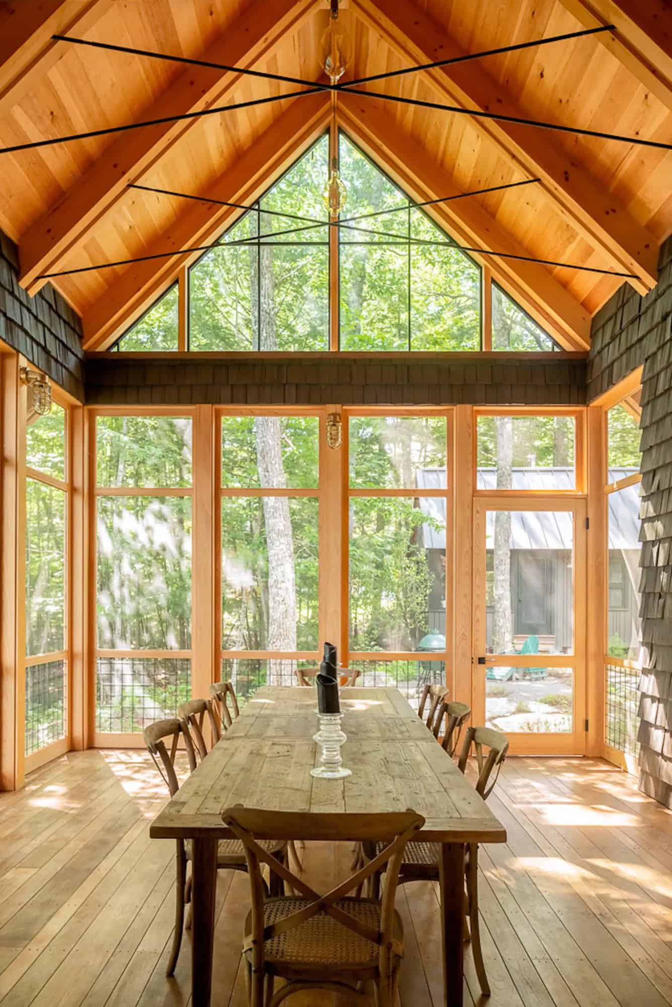 rustic screened porch with a dining table