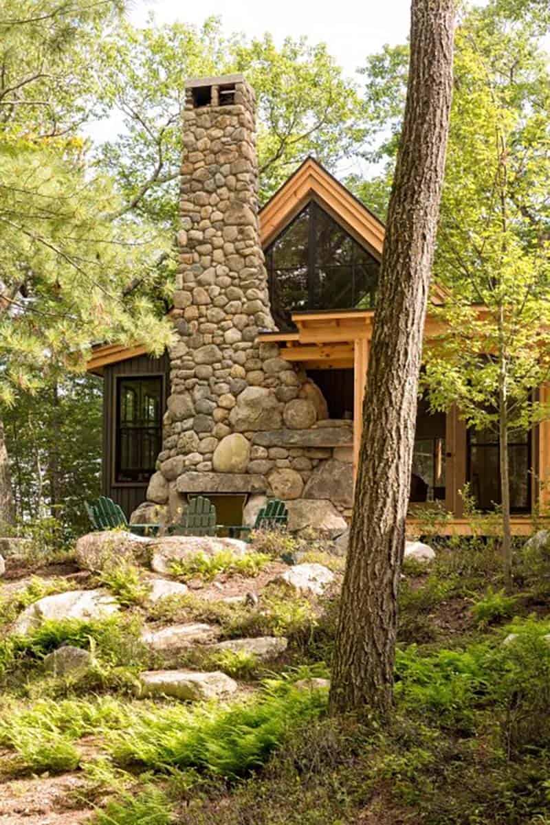 rustic cabin exterior with a stone chimney