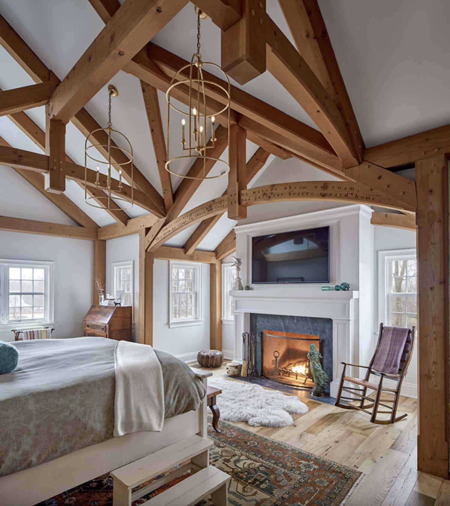 historical farmhouse style bedroom with a fireplace and wood ceiling trusses