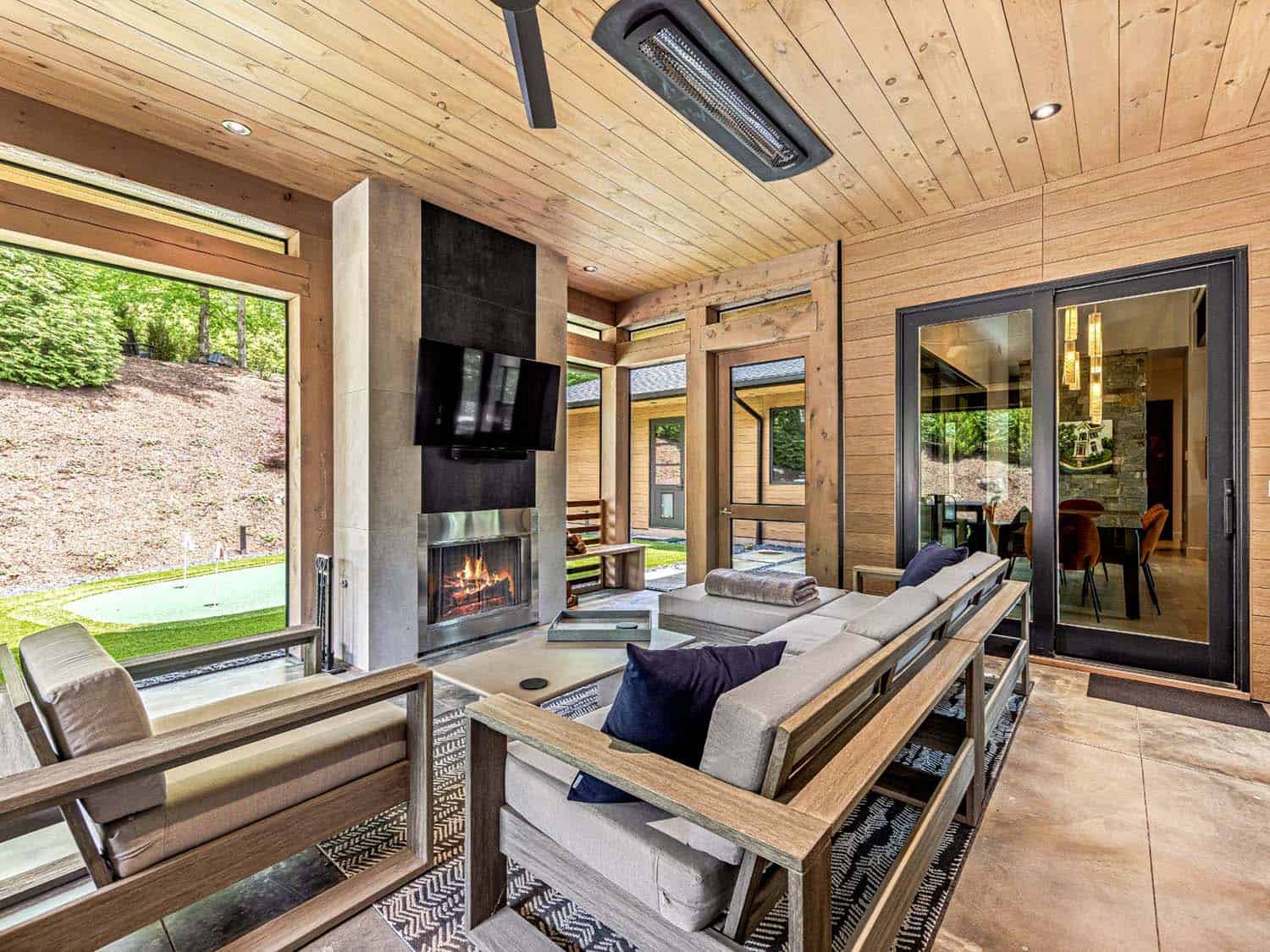 modern screened porch with heaters and a fireplace 