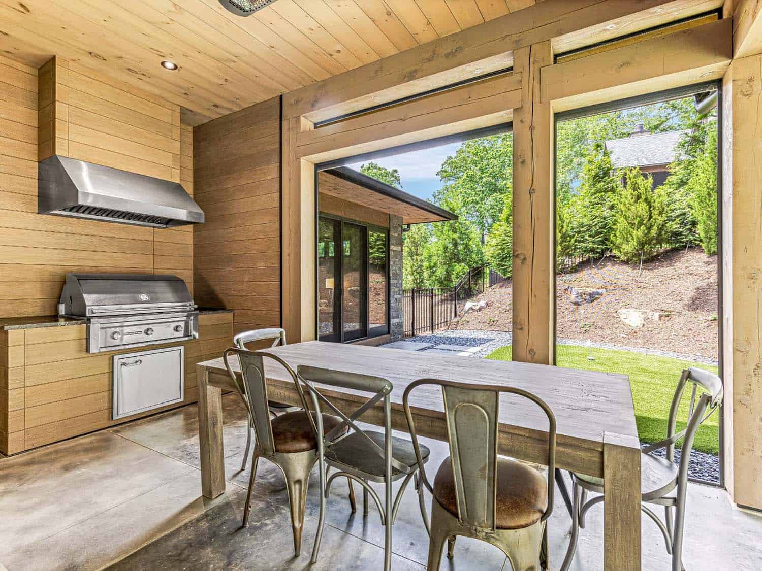 modern covered porch with an outdoor kitchen and dining area