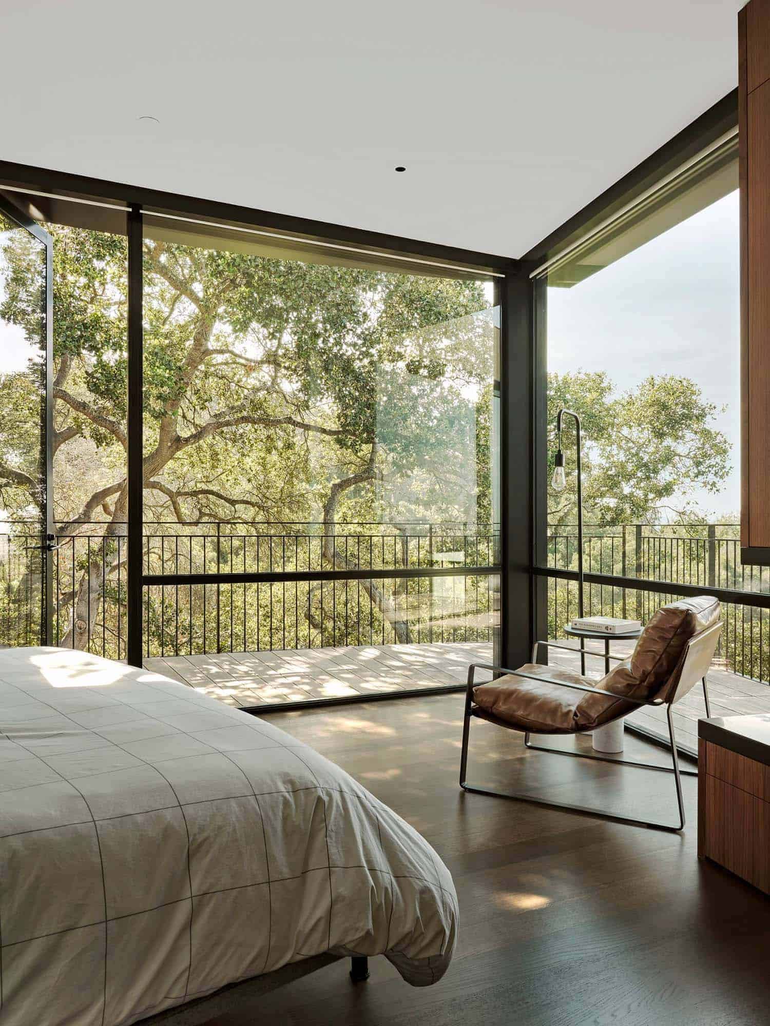 minimalist bedroom with large windows and tree views