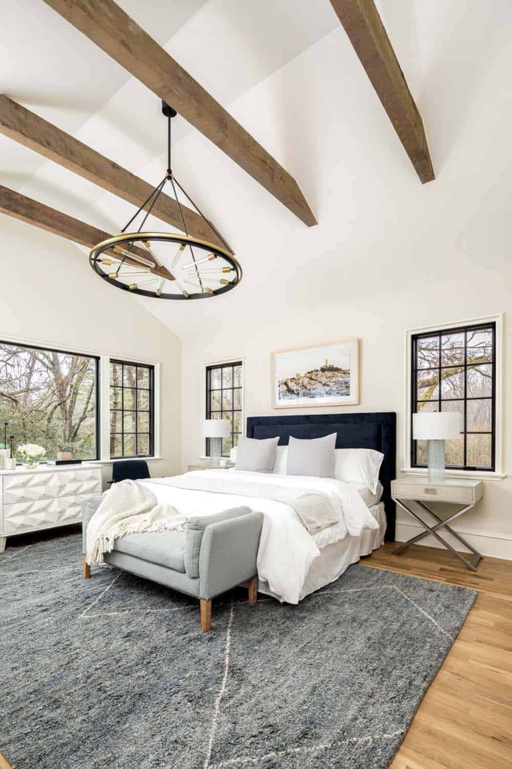 modern bedroom with tall ceilings and wood beams 