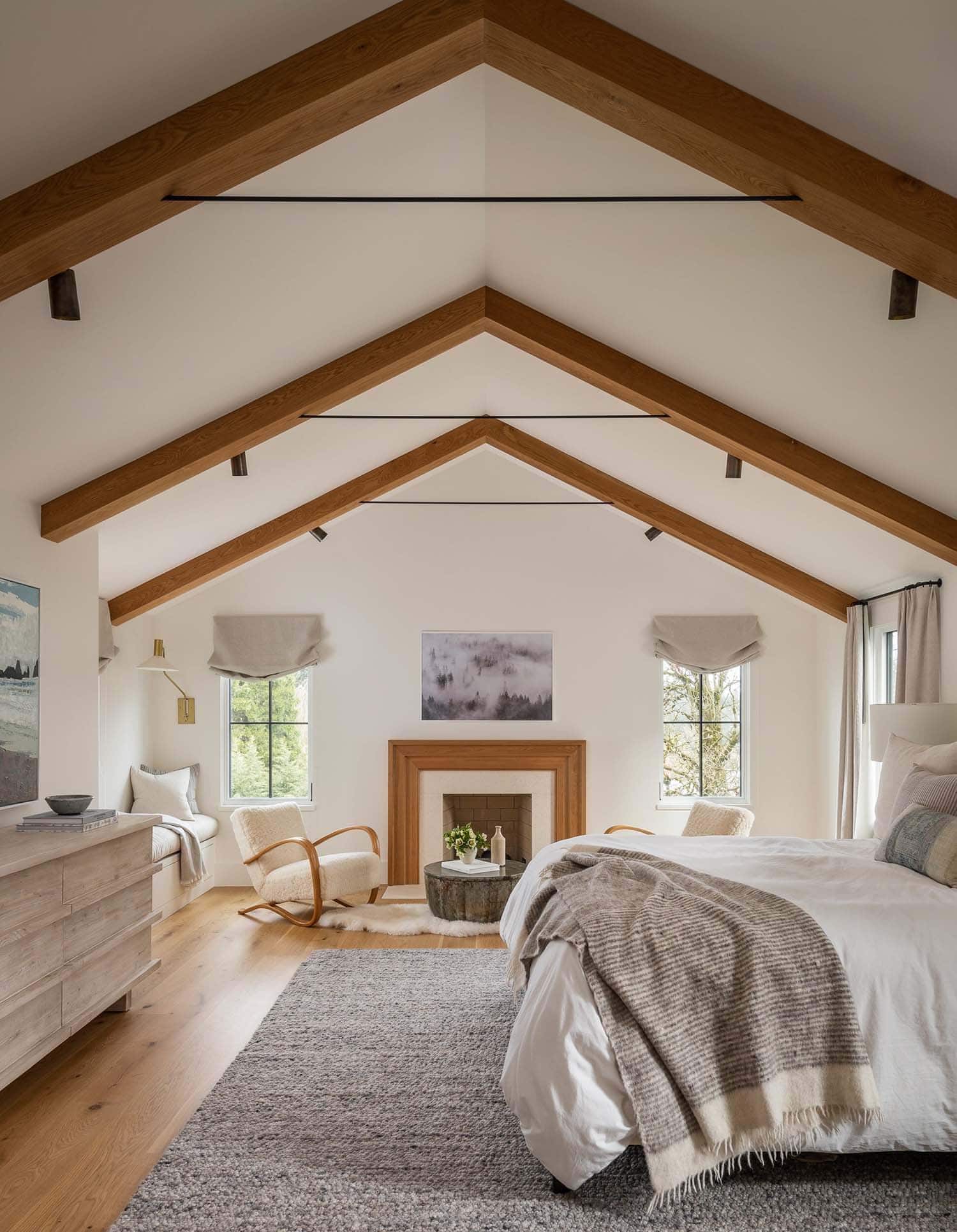 farmhouse style bedroom with vaulted ceiling and a fireplace