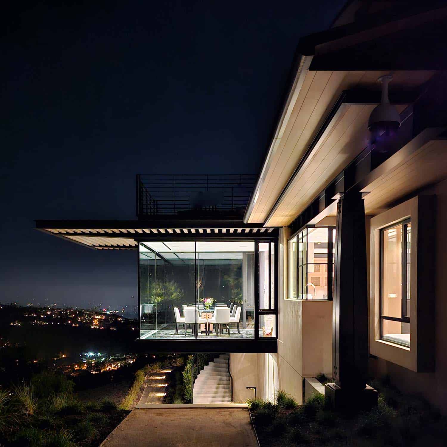 modern hilltop house exterior dining room cantilever at dusk
