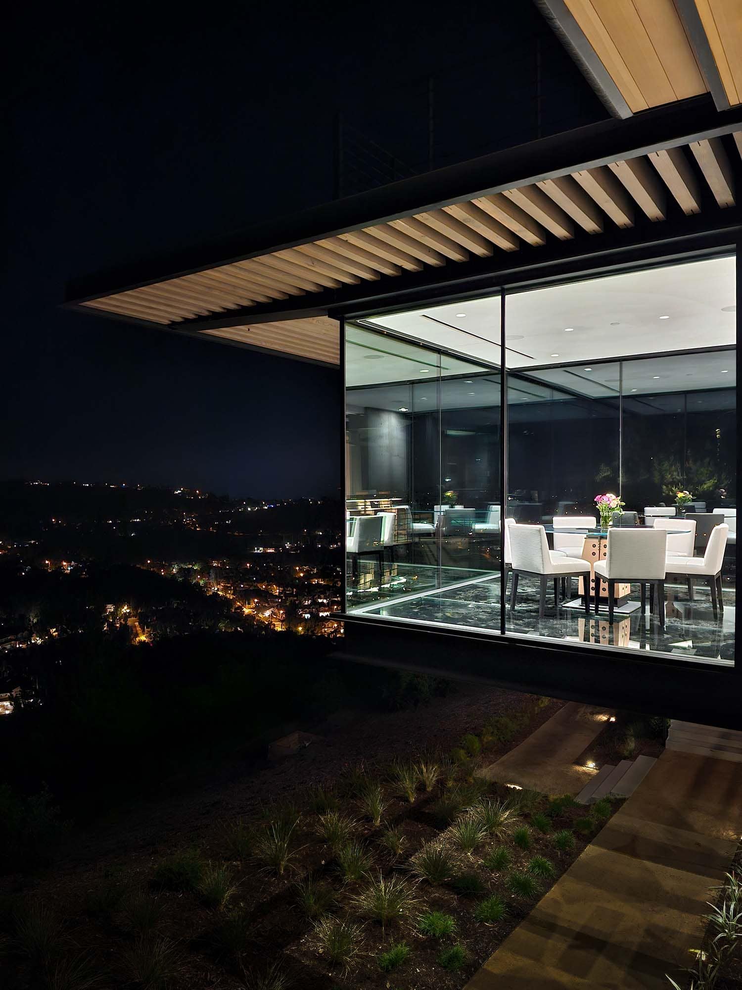 modern hilltop house exterior dining room cantilever at dusk