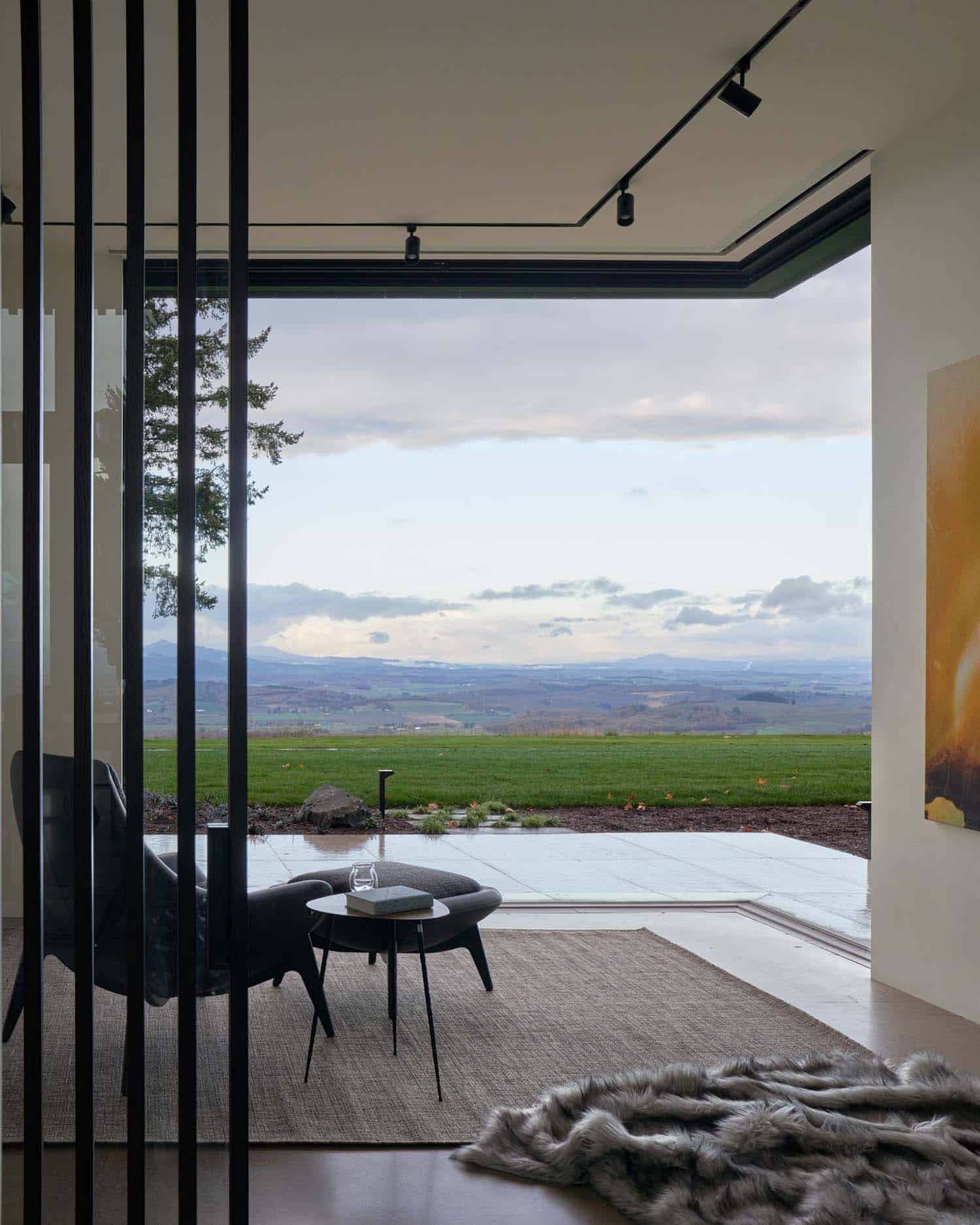 modern reading nook with walls of disappearing glass overlooking rolling hills