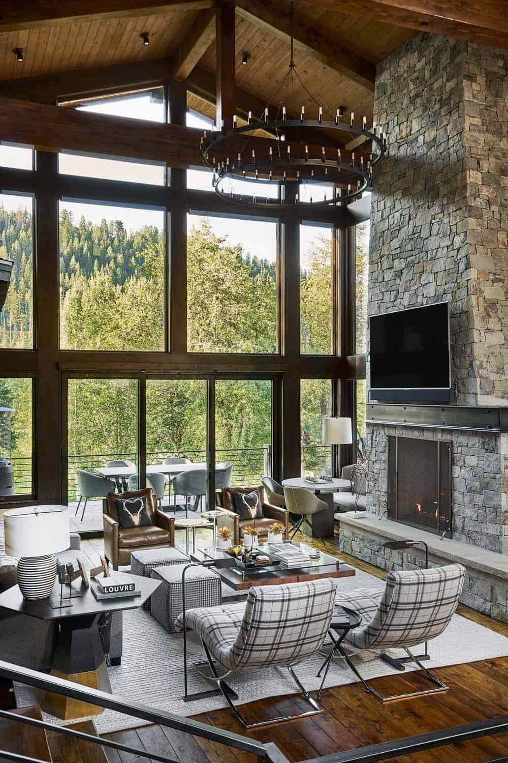 mountain contemporary living room with large windows and a fireplace 