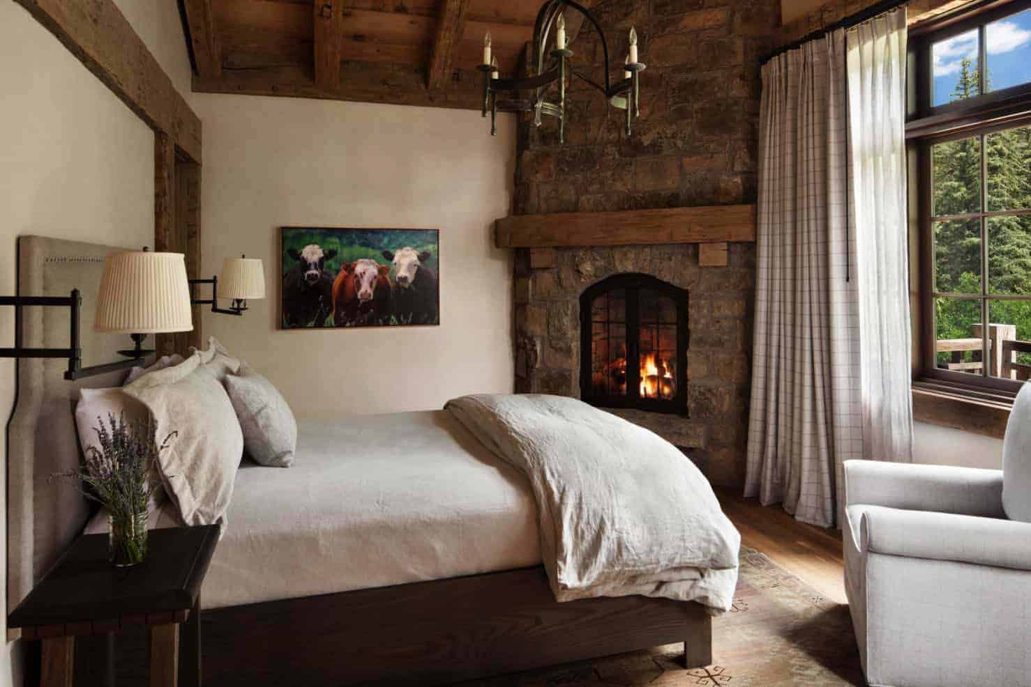 mountain ranch-style bedroom with a stone fireplace