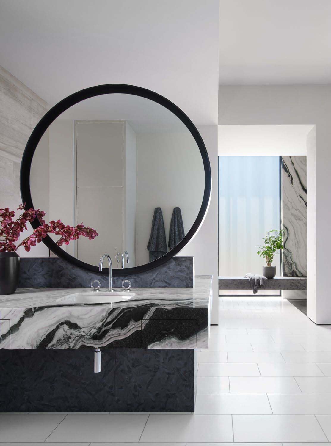 modern bathroom vanity with a large round mirror