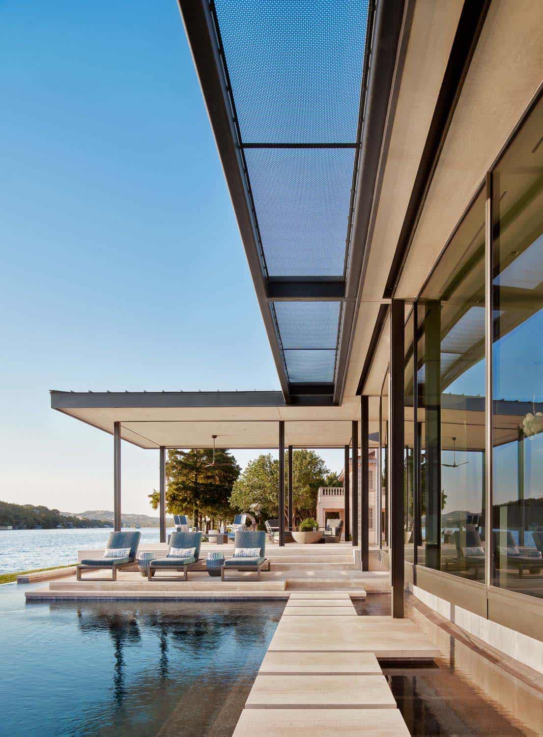 modern lake house exterior with a pool and lake view