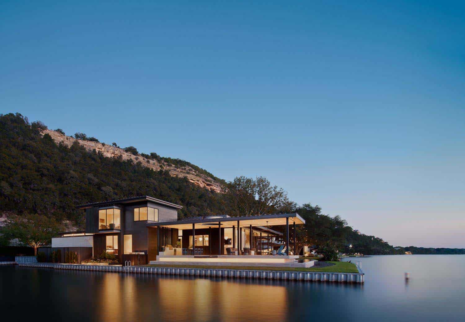 modern lake house exterior at dusk with a view from the water